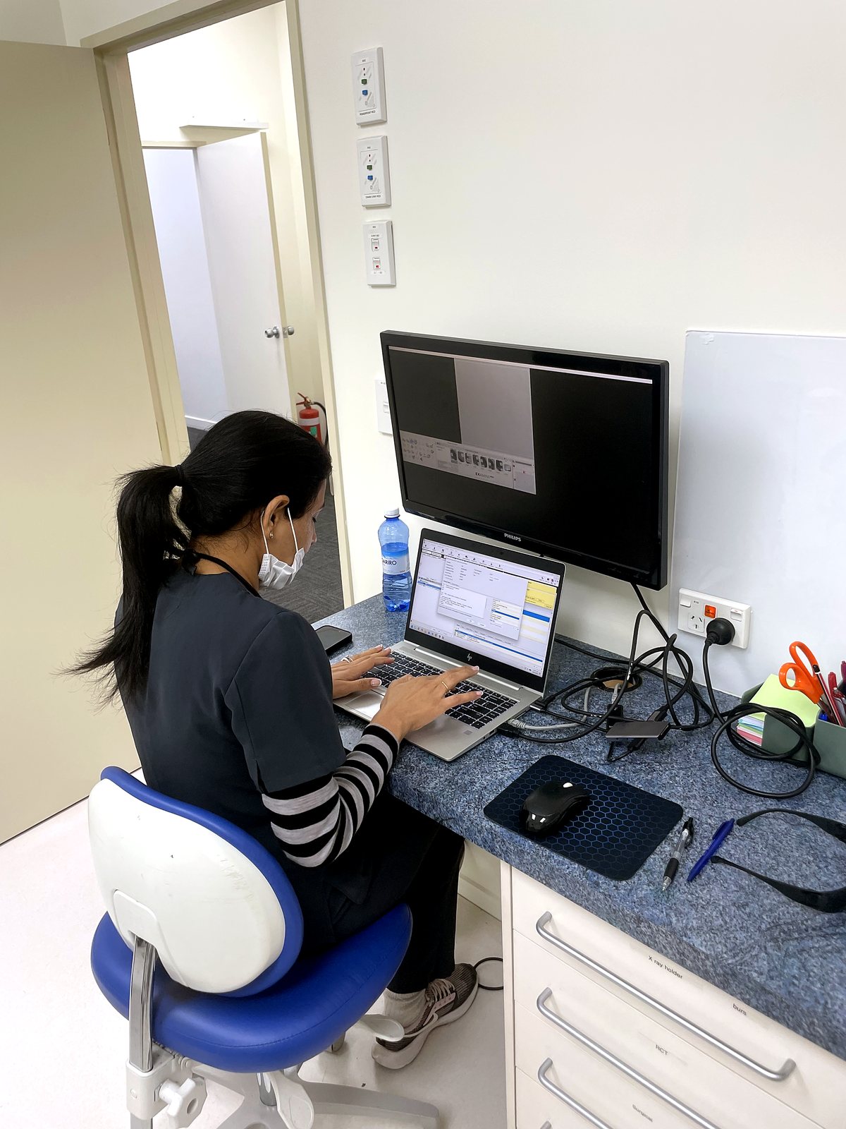 Dr Simran reviewing digital patient records and X-rays at the chairside workstation