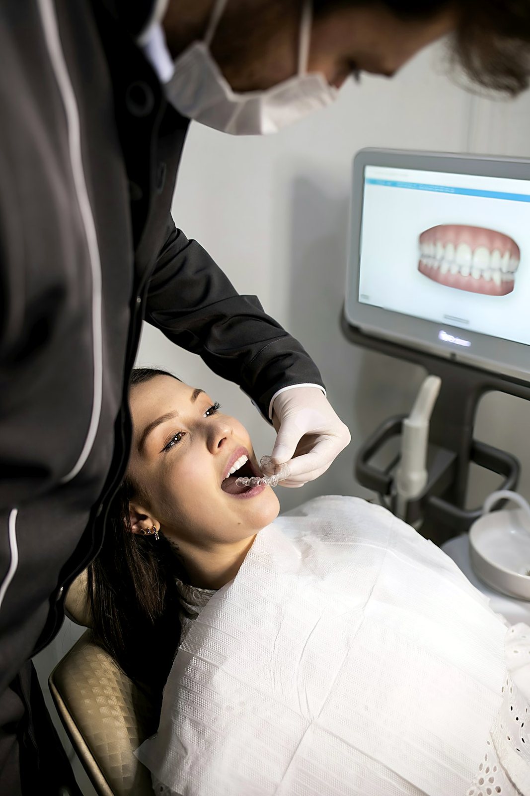 A dentist showing a patient what the check-up found on the chairside screen