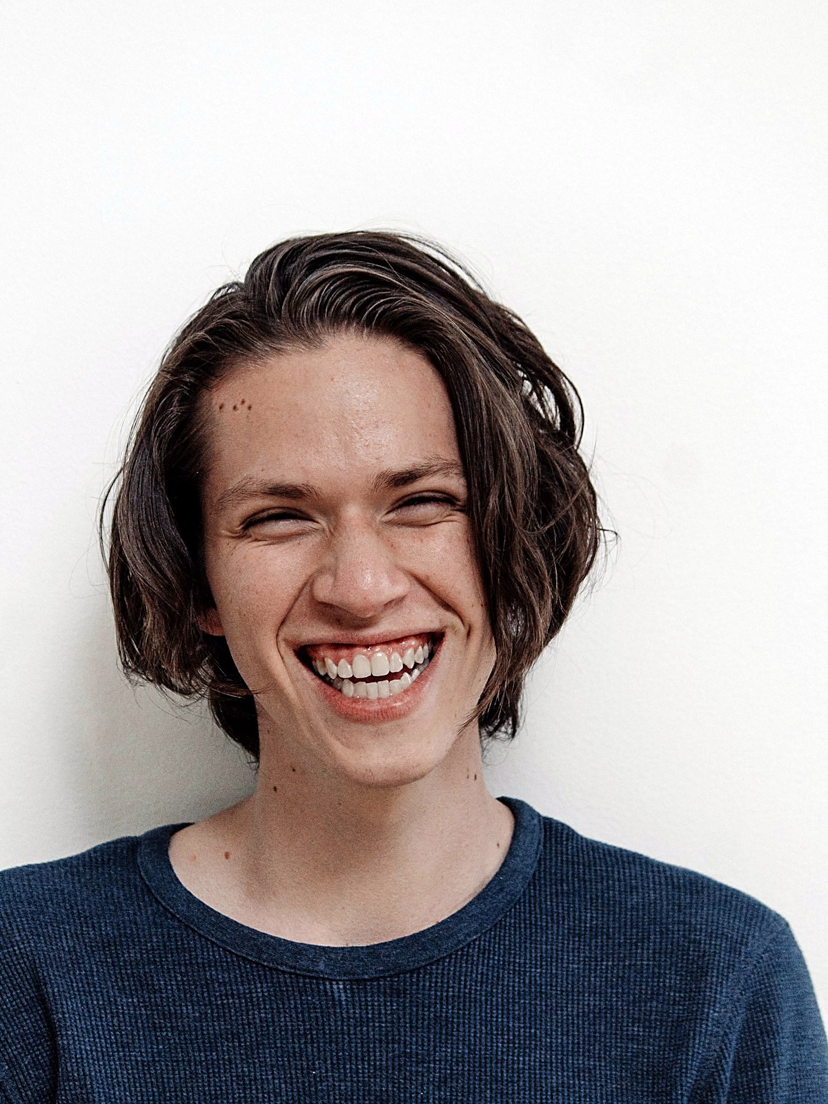 A relaxed young adult smiling