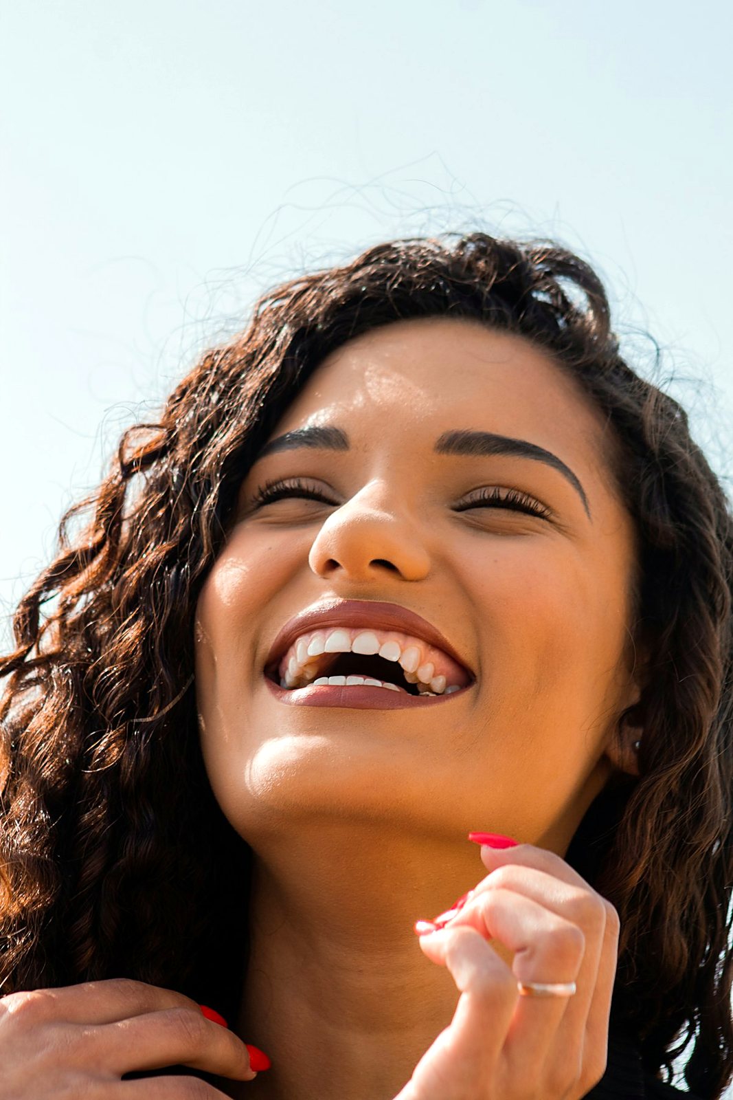 A person laughing with a fresh, healthy smile