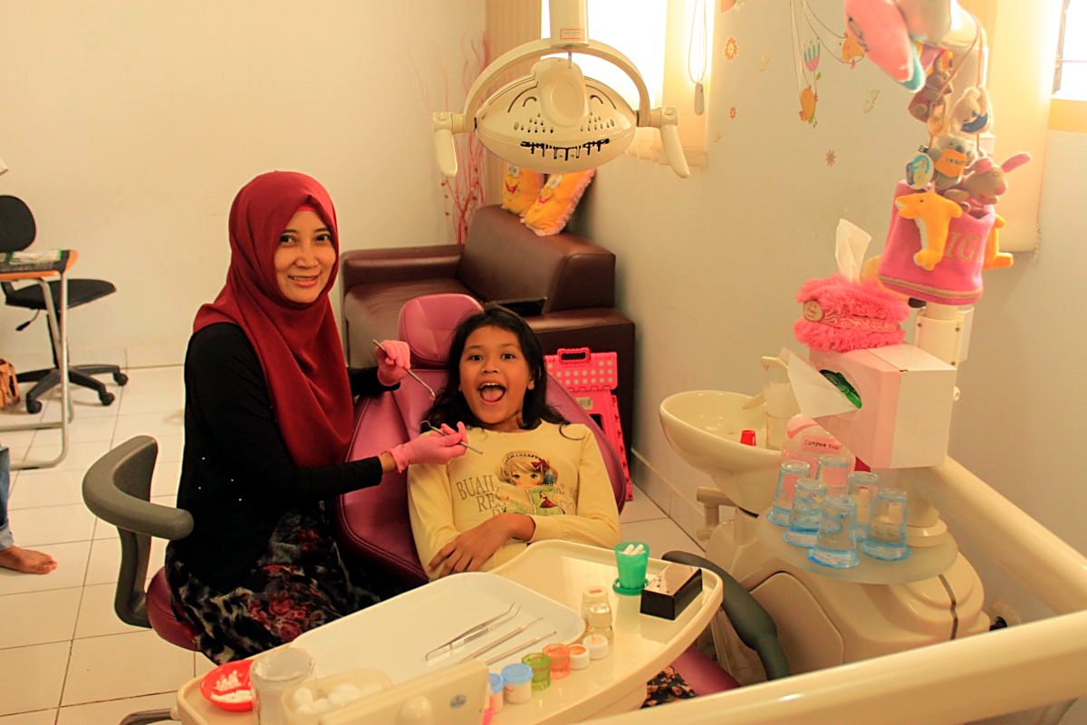 A child smiling at a friendly, colourful dental visit