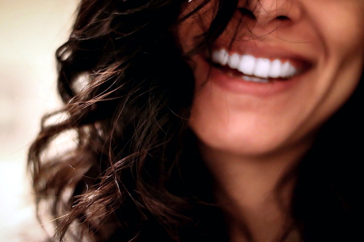 A woman laughing with a bright, natural smile